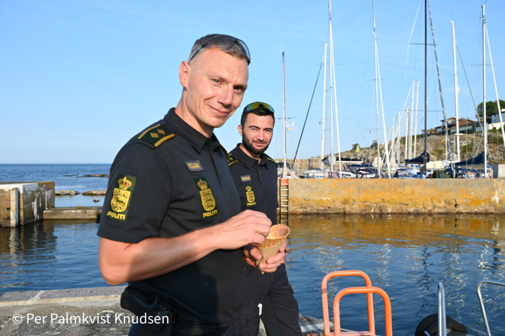 To betjente spiser is på kajen i fredfyldte Gudhjem